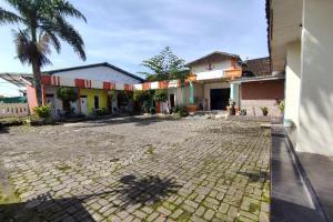 a courtyard of a building with a palm tree at SPOT ON 91105 Hotel Salsabila in Magelang