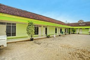 a courtyard of a building with green and yellow at Hotel O Sejahtera Syariah in Umbulan Tulungmeris
