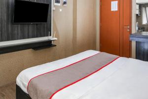 a room with a bed and a flat screen tv at Capital O 93372 Aurora Residence in Tangerang