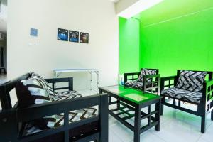 a room with three chairs and a green wall at OYO Life 3078 Kost Putri Made in Surabaya