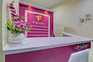 a pharmacyacist with a vase of flowers on a counter at Hotel O Family Guest House Syariah in Tulungagung
