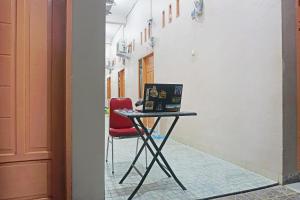a red chair sitting next to a table with a laptop at Hotel O Almeerah Homestay Syariah Near RS Hermina in Pampang