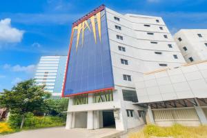 a tall white building with yellow reflections on it at Townhouse Oak Ancol in Jakarta