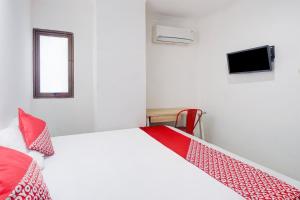 a bedroom with a bed and a tv on the wall at Townhouse Oak Ancol in Jakarta +29 photos