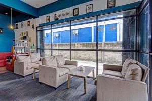 a living room with couches and a large window at Collection O 91499 John Lebron House in Sagulung