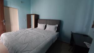 Hotel O Pinus Jaya SyariahNearTaman Amaryllis Pekanbaru في Palas 2: غرفة نوم بسرير كبير مع ملاءات ووسائد بيضاء +16 صورة