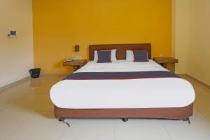 Rúm í herbergi á SUPER OYO Collection O 92130 Hotel Fiducia Kaji