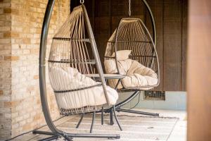 deux chaises suspendues avec des oreillers sur un porche dans l'établissement Cozy Cabin - Hot Tub - State Park - Near Lake, à Appomattox 46 autres photos