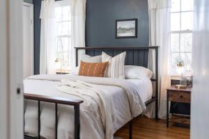 une chambre avec un lit avec des murs et des fenêtres bleus dans l'établissement Cozy Cabin - Hot Tub - State Park - Near Lake, à Appomattox