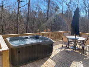 un jacuzzi sur une terrasse avec une table dans l'établissement Cozy Cabin - Hot Tub - State Park - Near Lake, à Appomattox