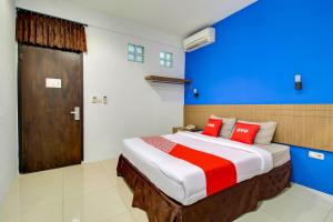 a bedroom with a large bed with red pillows at Collection O near Paris Van Java formerly Cassa Dua Hotel in Bandung