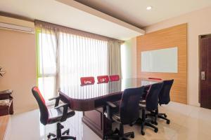 a dining room with a table and red chairs at Collection O near Paris Van Java formerly Cassa Dua Hotel in Bandung
