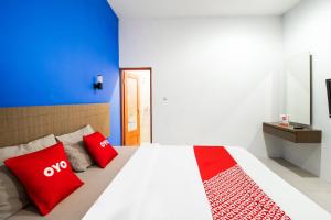 a bedroom with a bed with red pillows on it at Collection O near Paris Van Java formerly Cassa Dua Hotel in Bandung