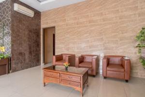 una sala d'attesa con sedie in pelle e tavolo di Hotel O Medan near Balai Kota Lama formerly Hotel Labuhan Raya a Medan Altre 25 foto