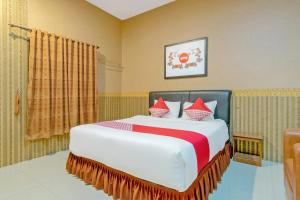una camera da letto con un letto grande con cuscini rossi di Hotel O Medan near Balai Kota Lama formerly Hotel Labuhan Raya a Medan