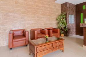 a waiting room with leather chairs and a table at Hotel O Medan Near Gajah Mada formerly Hotel Indah Raya in Medan