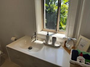 a white sink in a bathroom with a window at Frogs by the Sea in Cronulla +41 photos