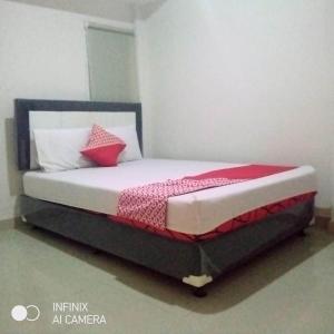 a bed with red and white pillows in a room at Hotel O 77 Guesthouse in Tjilandak