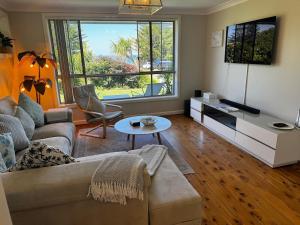 a living room with a couch and a table at Frogs by the Sea in Cronulla
