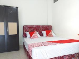 Un dormitorio con una cama con almohadas rojas y blancas. en OYO Life 2664 D'kost, en Bekasi