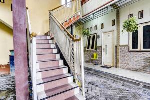 a staircase in a house with a brick wall at OYO 91795 Kos Jeehel Syariah in Sidoarjo