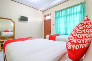 Postel nebo postele na pokoji v ubytování Super OYO 1654 Maha Bharata Kuta Inn