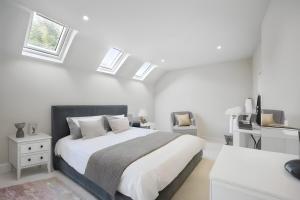 a white bedroom with a large bed and skylights at Spacious 4BedNear Nottingham Derby Sleeps 8 in Long Eaton