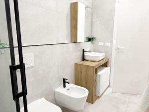 ein weißes Badezimmer mit Toilette und Waschbecken in der Unterkunft Casa A'mar in Giardini-Naxos + 15 Fotos