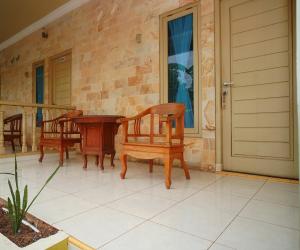 two chairs and a table on a patio at Hotel O near Universitas Widya Dharma formerly Nugraha Residence in Talang Kelapa