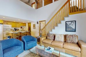 a living room with a couch and chairs and a kitchen at Big Views at Red Pine in Park City
