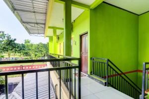 a balcony of a green building with a staircase at Hotel O Cahyo Kost 1 in Semarang