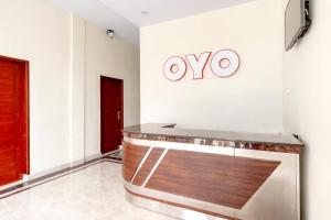 a lobby with an ovy sign on the wall at Capital O 1585 Ring Road Residence in Medan