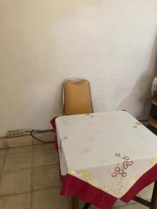 a table and a chair with a table cloth on it at Hotel O Rumah Oma Syariah in Kupang