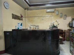 a counter in a room with a clock on the wall at Hotel O Baruga Makassar in Makassar