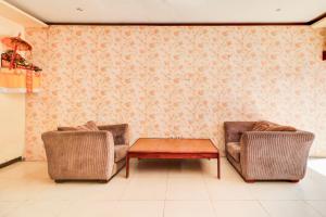 two chairs and a coffee table in a living room at Collection O Putri Inn Homestay in Sanur