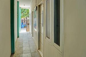 un corridoio vuoto di una casa con porte e pavimento piastrellato di OYO Life 92684 Kost Mutiara Nirwana a Gandang