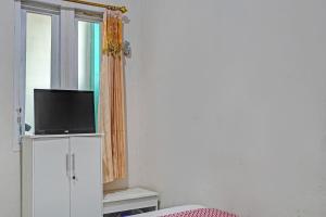 una camera con TV su un armadio e finestra di OYO Life 92684 Kost Mutiara Nirwana a Gandang