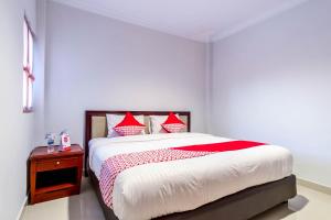 a bedroom with a large bed with red pillows at Hotel O Helvetia Residence in Medan