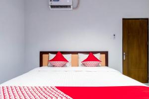 a bedroom with a large bed with red pillows at Hotel O Helvetia Residence in Medan