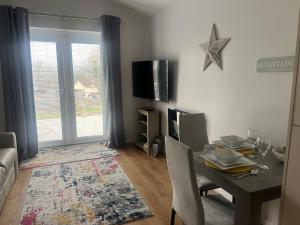 a living room with a dining table and a television at Mountain View in Kenfig Hill