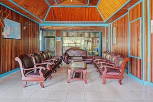 a waiting room with leather chairs and a table at Capital O 91806 Hotel Batu Suli in Palangkaraya +46 photos