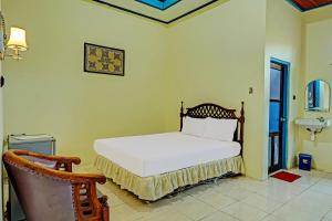 a bedroom with a white bed and a sink at Capital O 91806 Hotel Batu Suli in Palangkaraya