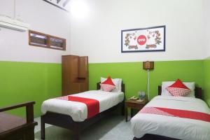 Rúm í herbergi á Super OYO 942 Srikandi Hotel