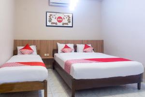Rúm í herbergi á Super OYO 942 Srikandi Hotel
