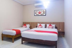 Rúm í herbergi á Super OYO 942 Srikandi Hotel
