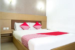 ein Schlafzimmer mit einem Bett mit roten und weißen Kissen in der Unterkunft Capital O 664 Romance Hotel in Nagoya