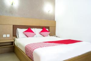 ein Schlafzimmer mit einem Bett mit roten und weißen Kissen in der Unterkunft Capital O 664 Romance Hotel in Nagoya