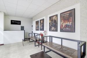 una sala d'attesa con panchine e fotografie sul muro di OYO Life 90388 De'leota a Semarang