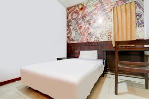 una camera con letto e scrivania con murale di OYO Life 90388 De'leota a Semarang