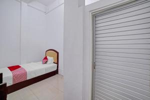 een slaapkamer met een deur naar een bed bij Hotel O Sepakat Guest House in Medan +21 foto's